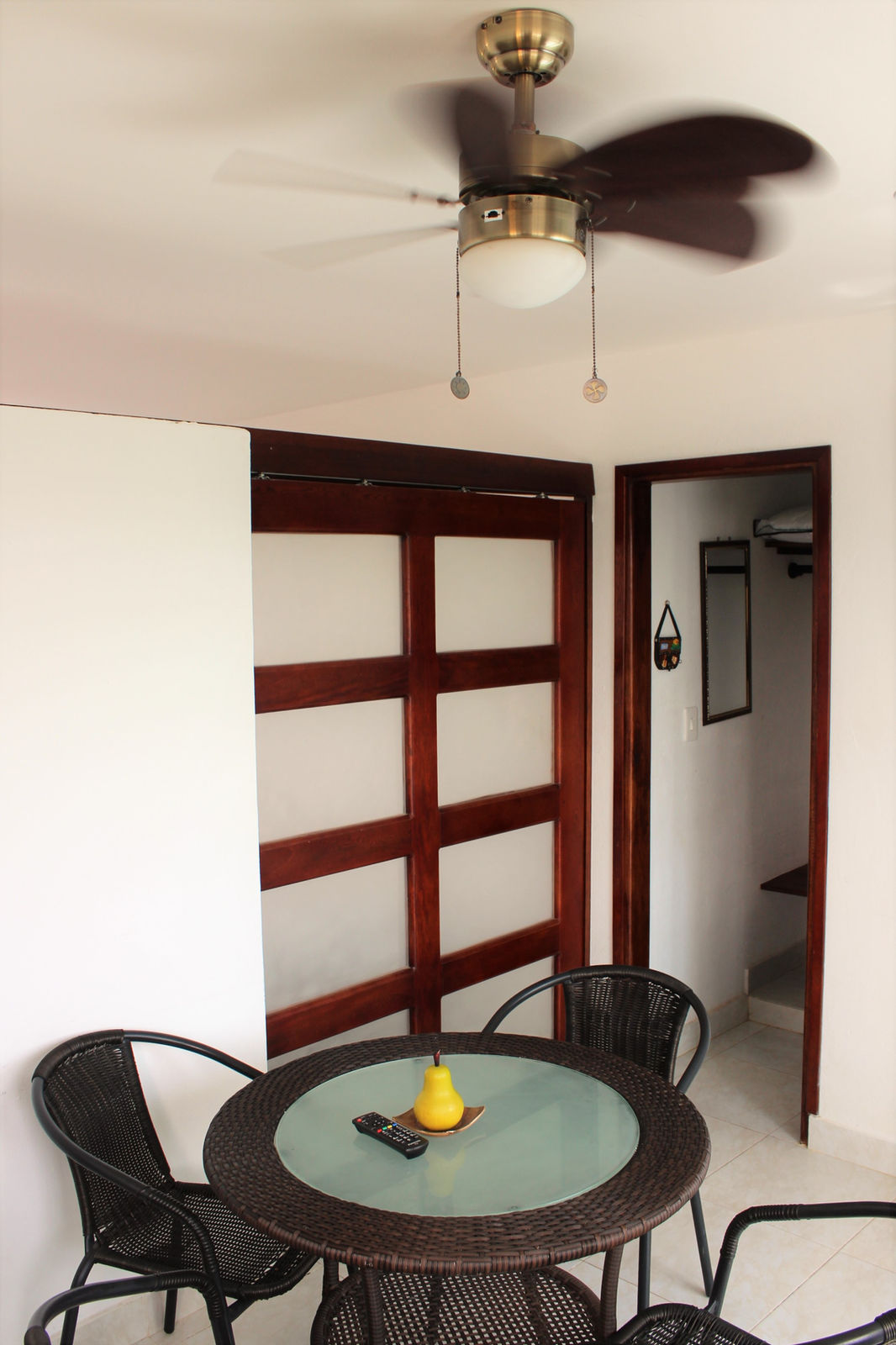 Comedor con mesa de vidrio y ventilador