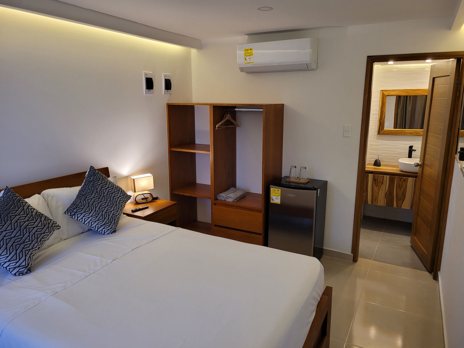 Cama doble, closet y entrada al baño en la habitación para parejas